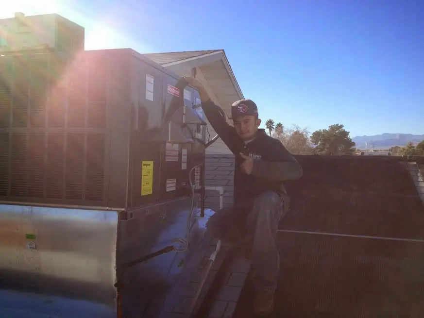 HVAC technician performing AC Tune-Up on a rooftop unit in Des Peres